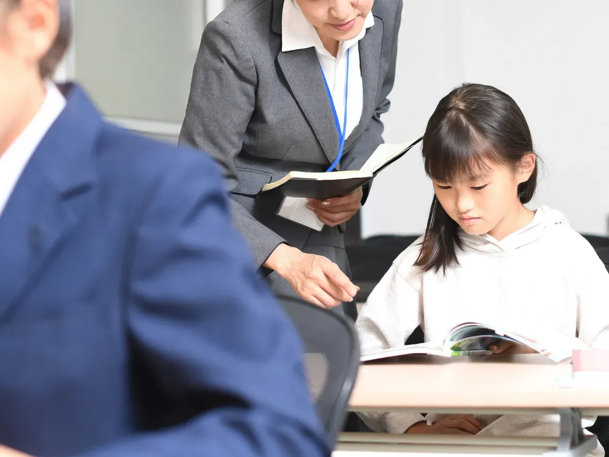 授業中に勉強をする女子学生と塾講師のイメージ