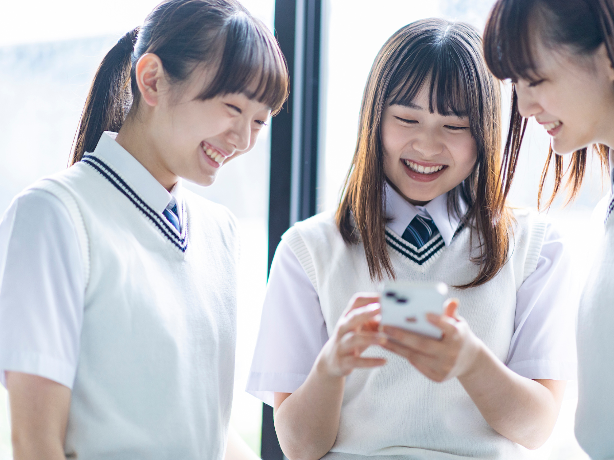 教室でSNSをみんなで見る高校生