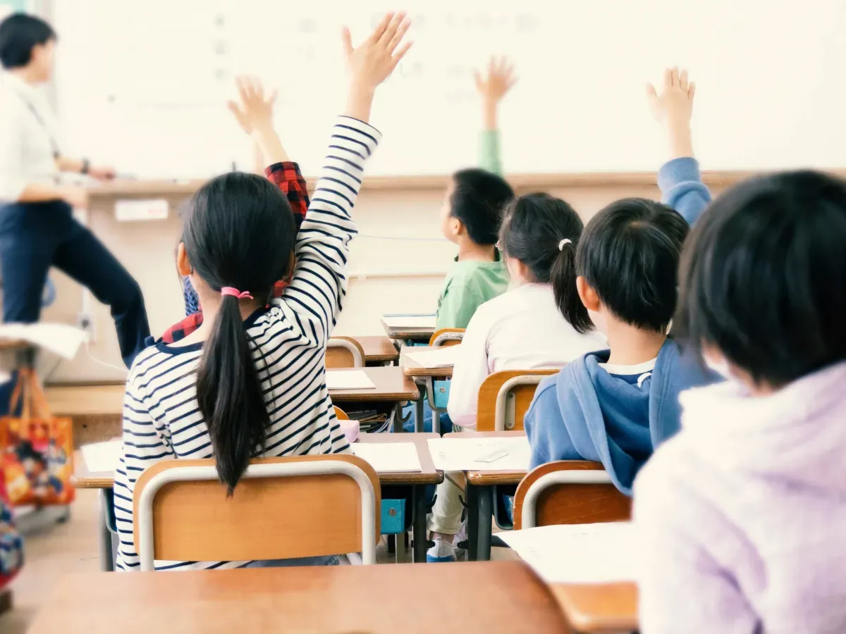 教室で手を上げる小学生